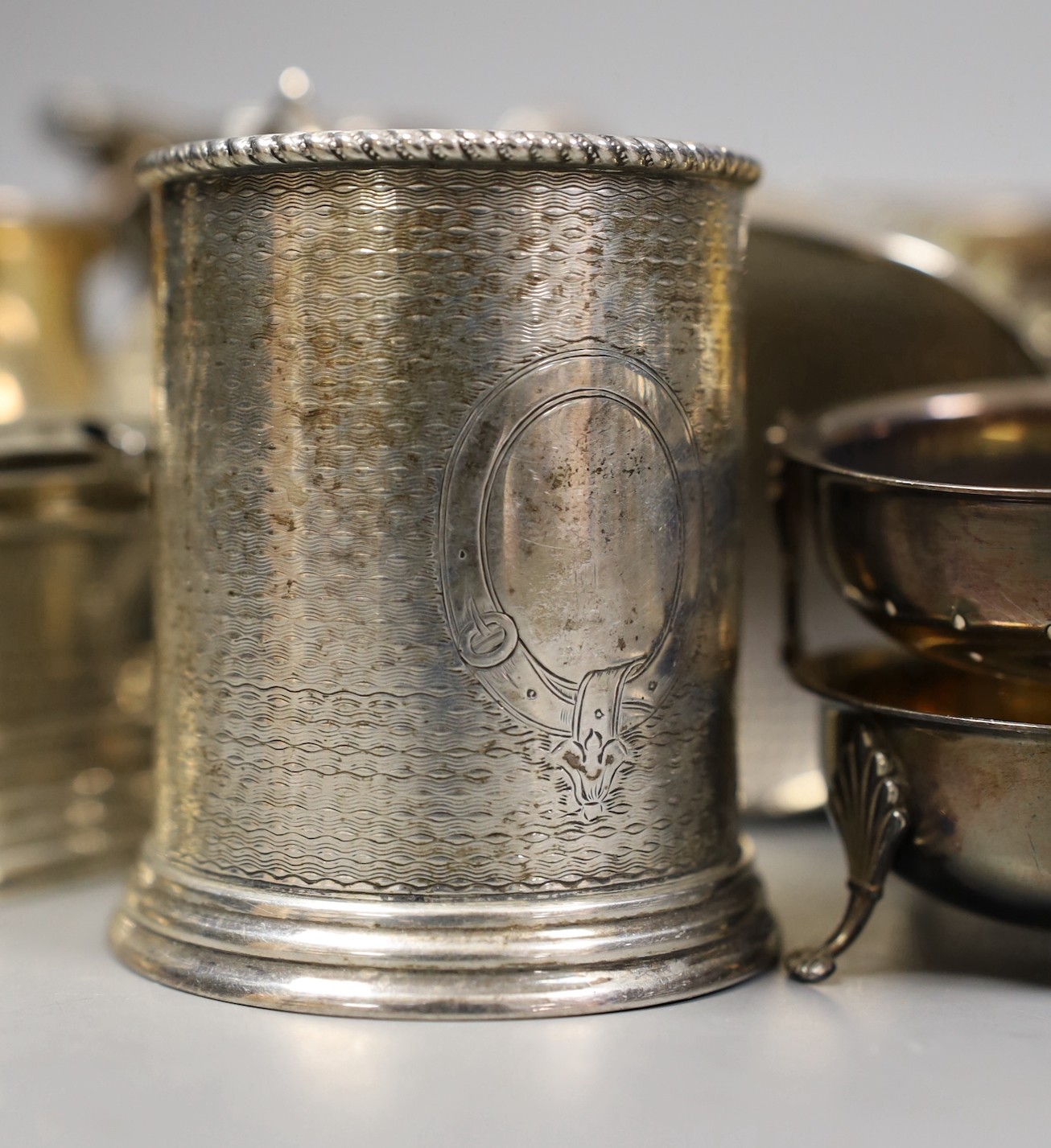 Mixed silver and white metal items including par of toastracks, sugar bowl match sleeve, sauceboat, cream jug, Victorian christening mug, pair of silver mounted clothes brushes, silver mustard silver cigarette case, 25.8